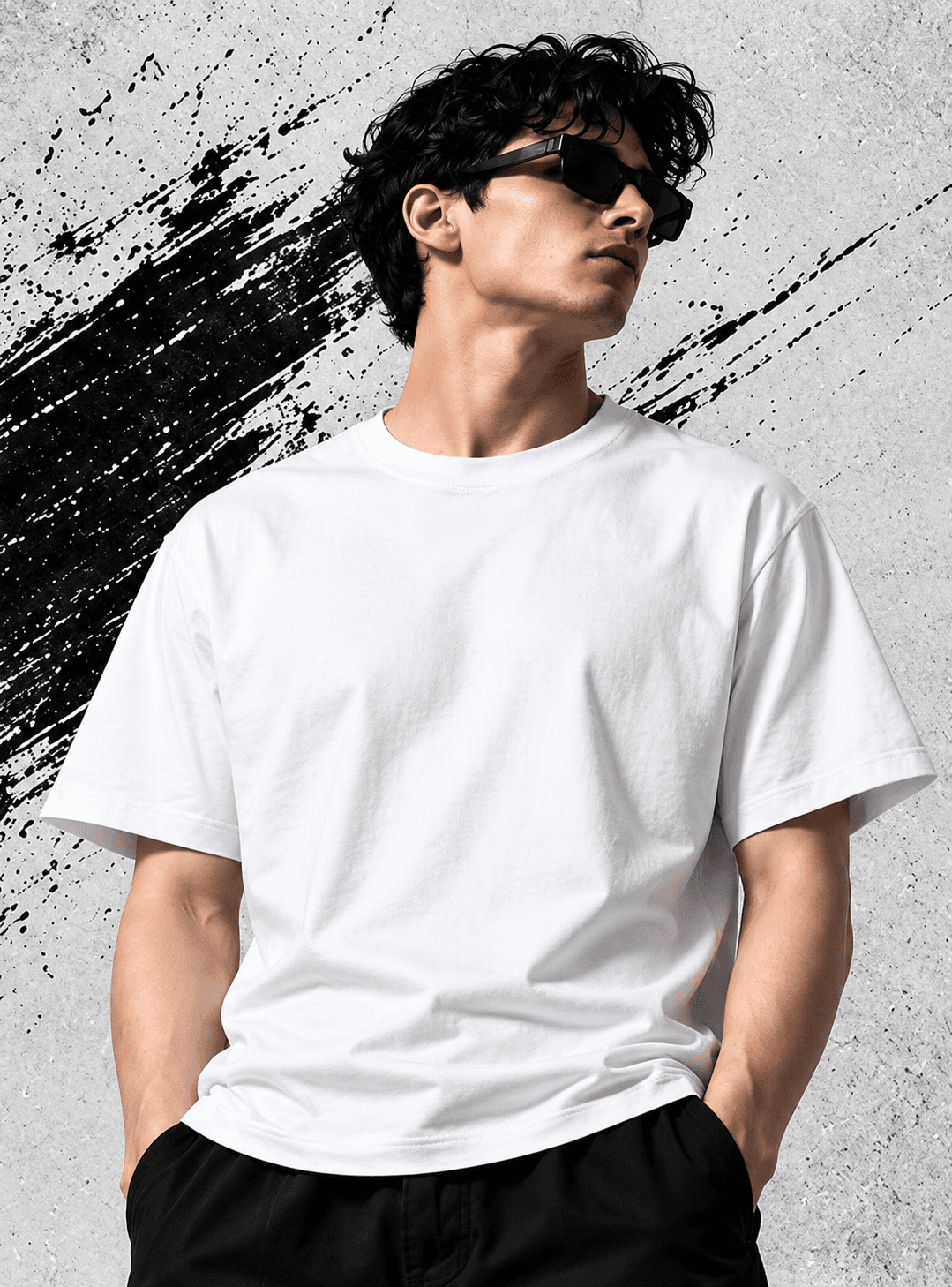 Model wearing a clean white oversized T-shirt with black trousers and sunglasses against a concrete wall